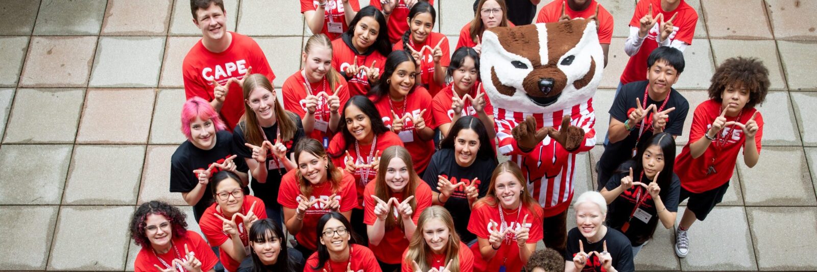 CAPE 2025 students stand on a patio with Bucky.