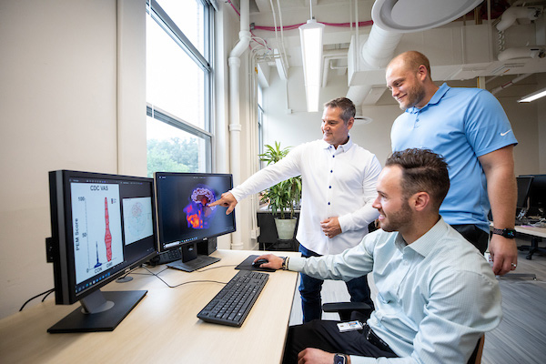 Image of three people pointing at research
