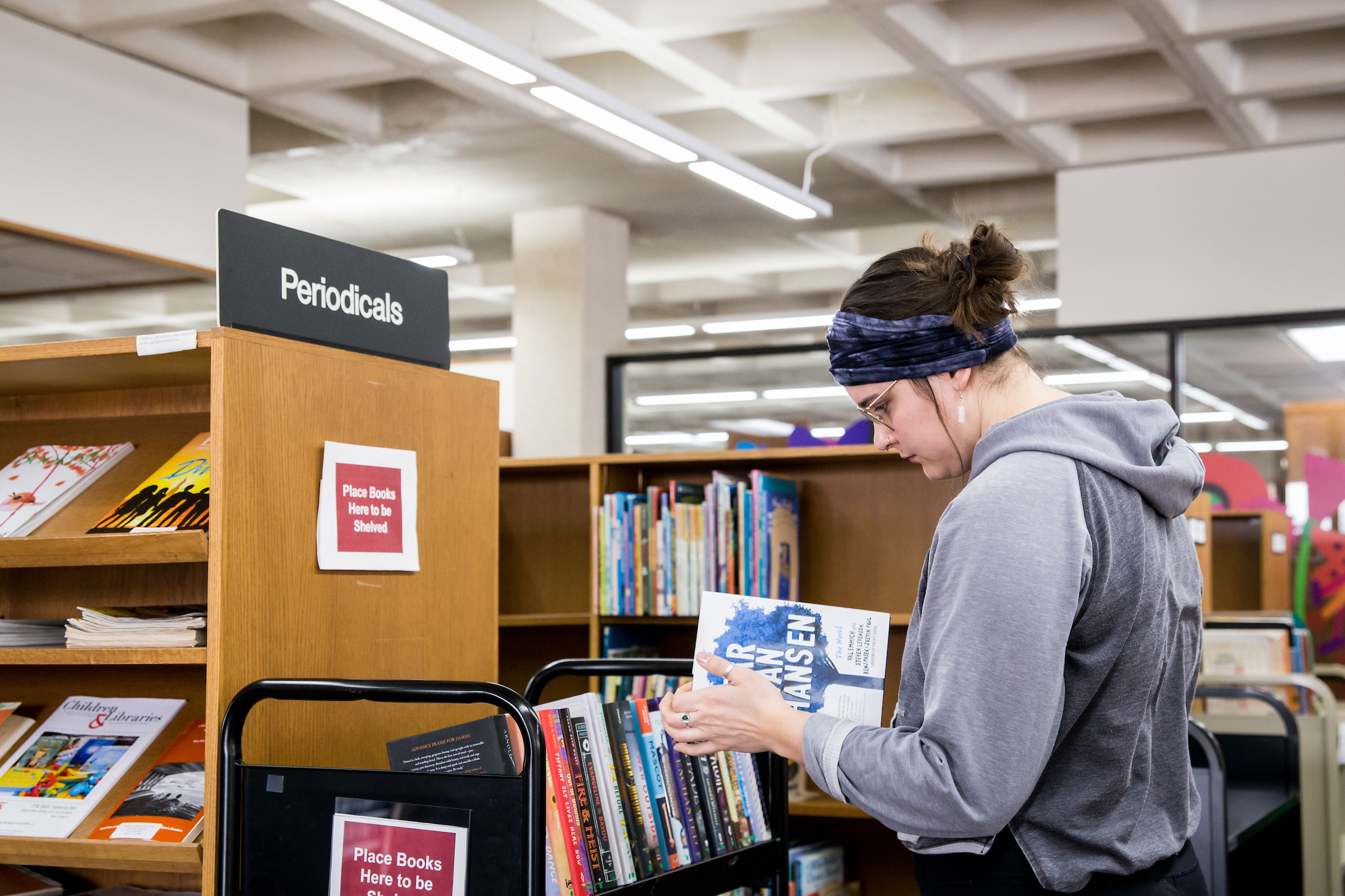 a person shelving books at a library