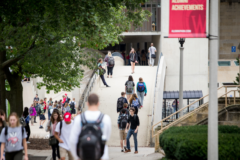 students walking across a bridge