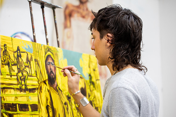 Student artist painting on canvas