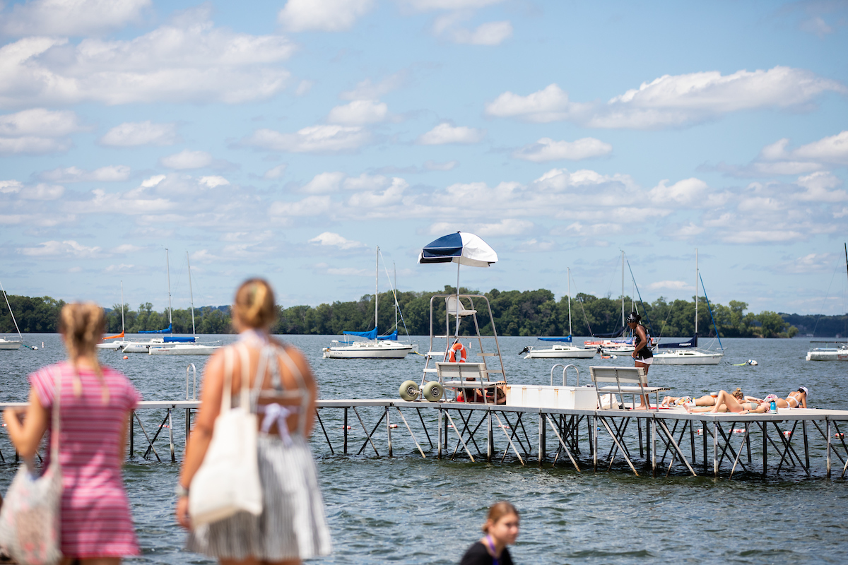 Summer scene in Madison with people strolling, sunbathing near Memorial Union