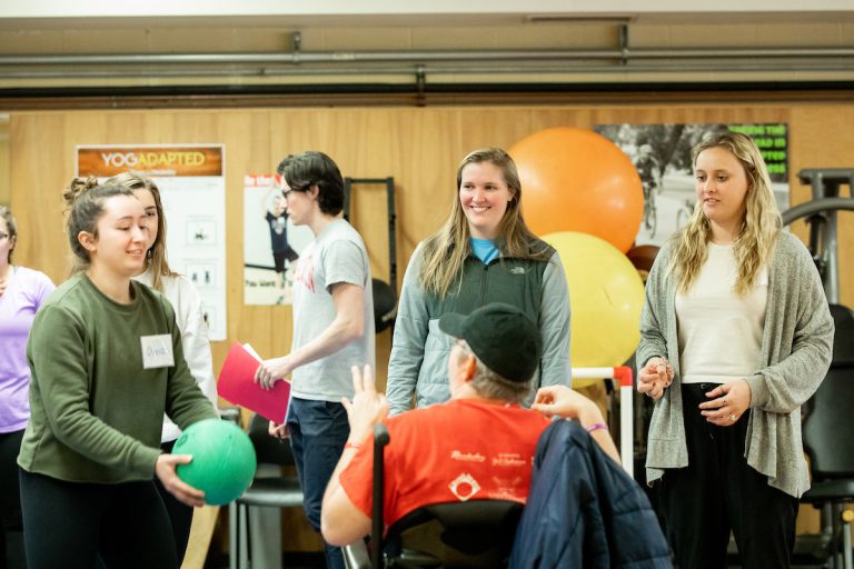 Student volunteers in the Department of Kinesiology’s Adapted Fitness program work closely with a client at the Natatorium.
