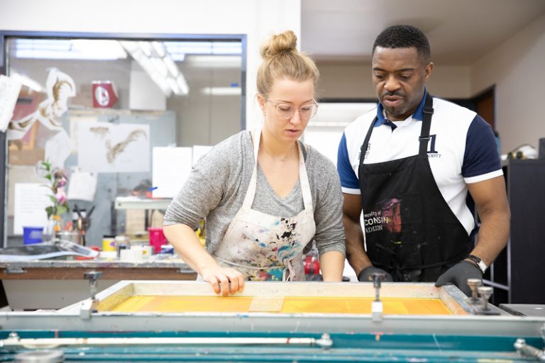 Professor Faisal Abdu’allah in the Art Department helps a student with screen printing.