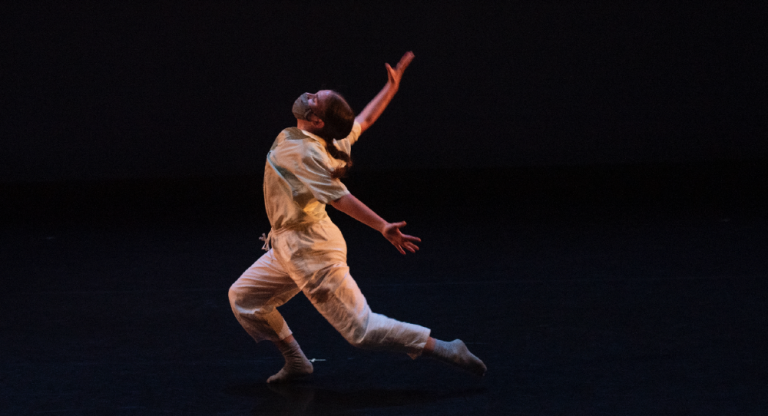 A masked-up dance alumna Megan Schimke performs a solo.