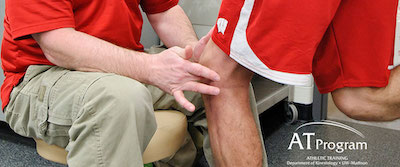 Athletic trainer working with student