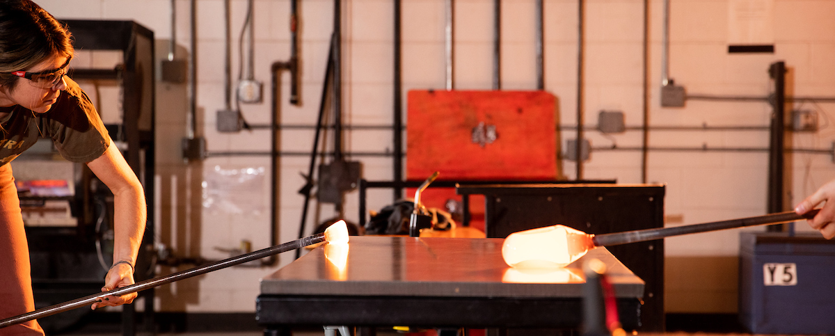 A graduate student works with glass