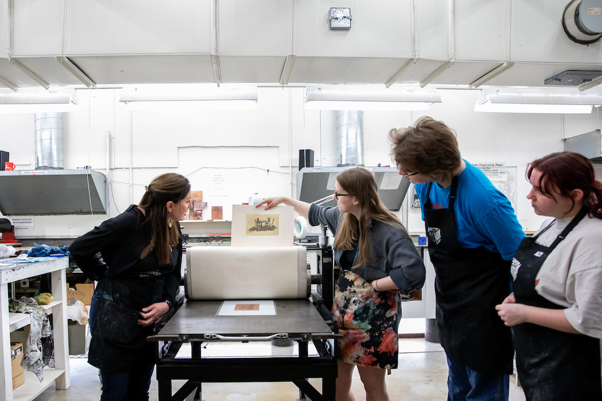students and a professor working in an etching class