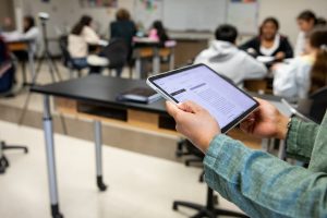 A dashboard on an iPad highlights small-group discussions for teachers