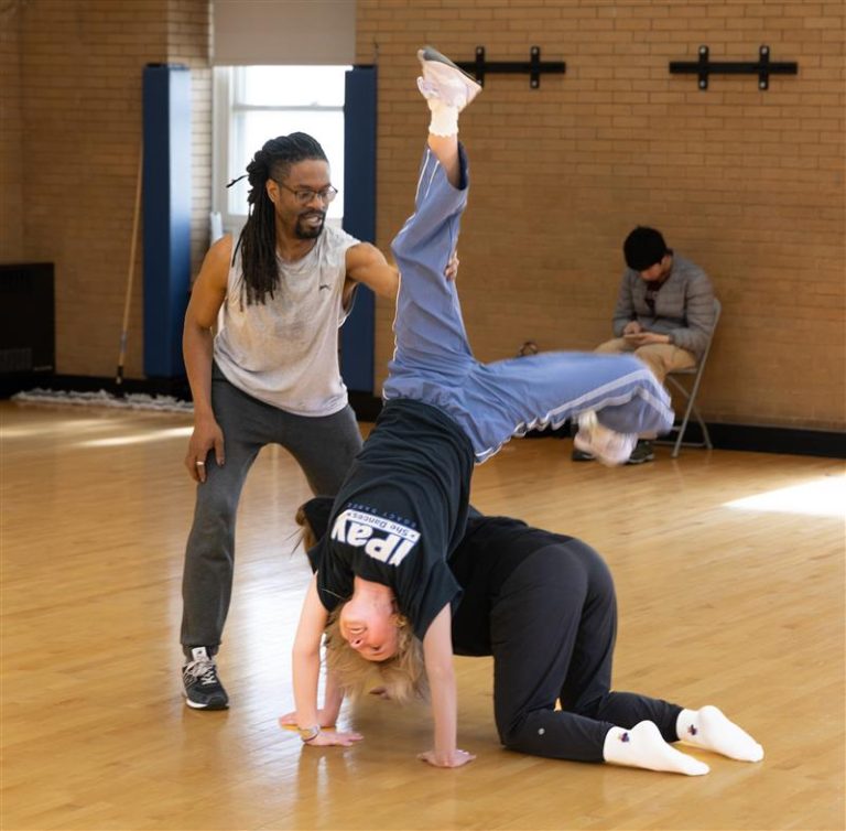 Carter watching two students dance and helping