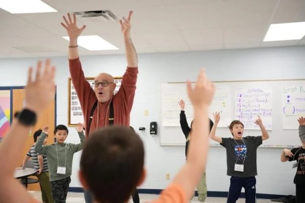 A Whoopensocker teaching artist works with Sugar Creek Elementary School students