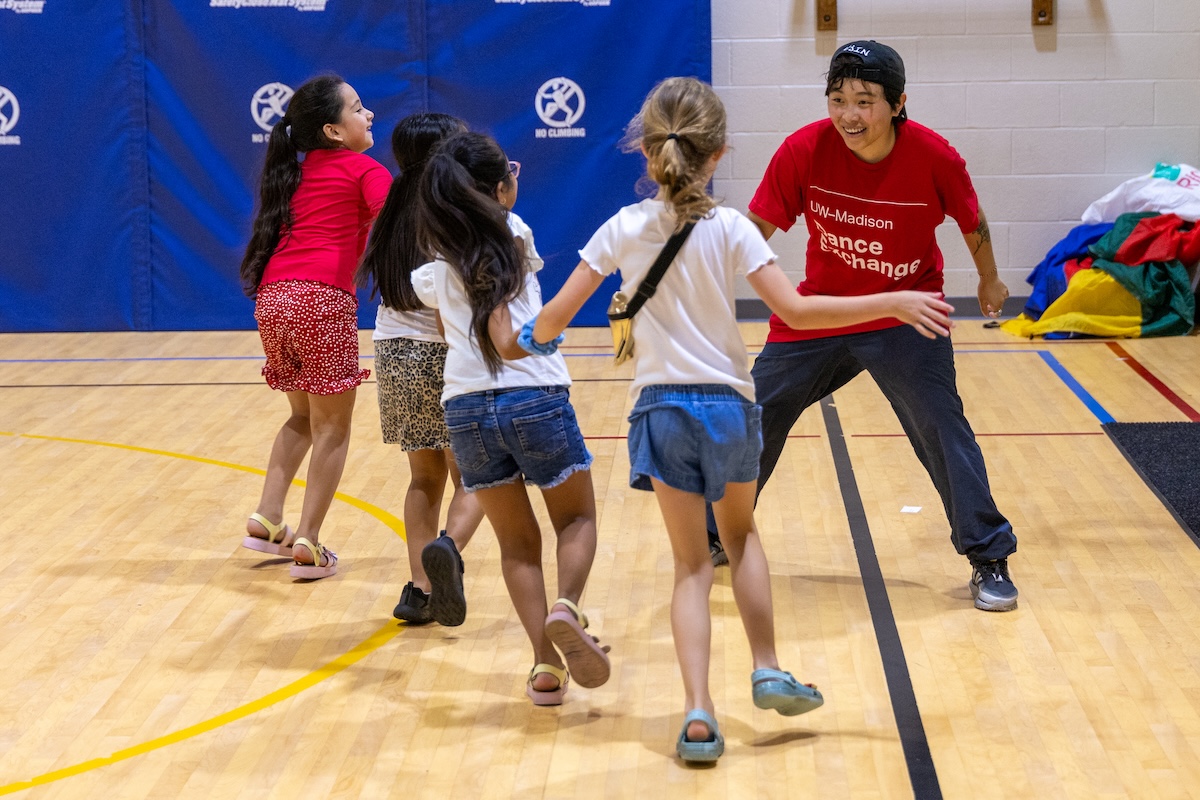 Dance student instructing children how to dance