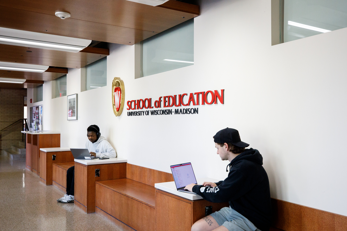 two students sitting in a hall studying