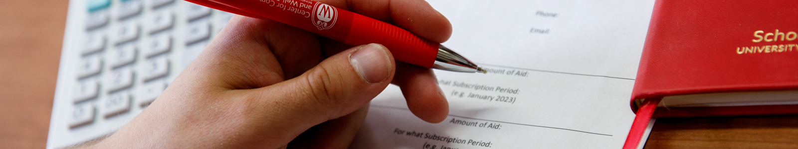 a hand filling out an application