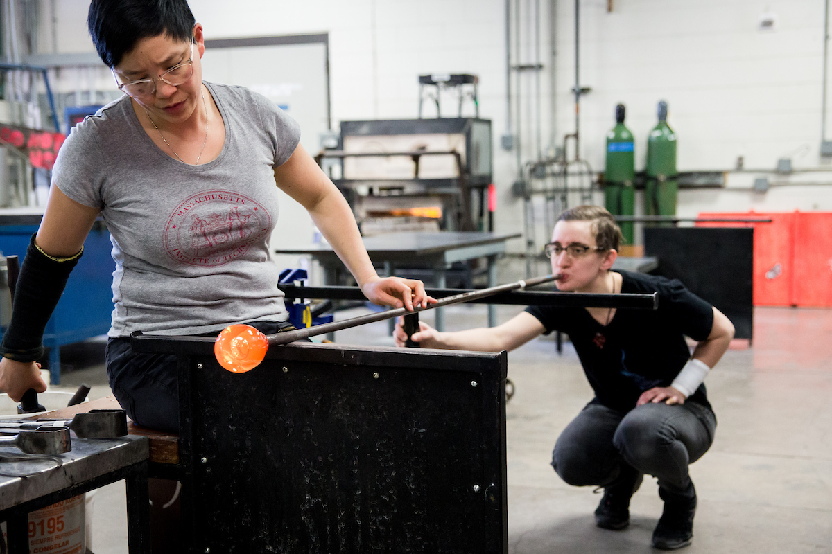 2 people working on a glass blowing project