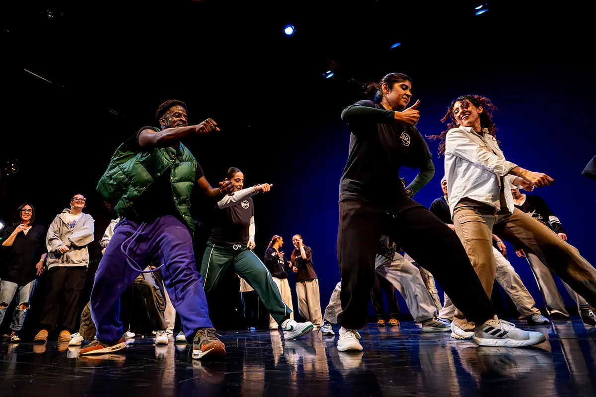 four people dance and smile