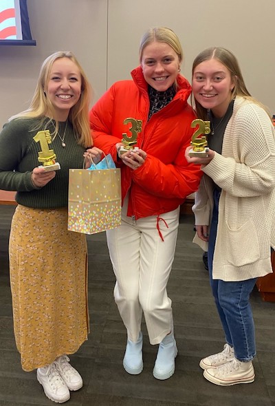 Sophia Schaubel, Ellie Pettus, and Livia Isaacs show off their trophies.