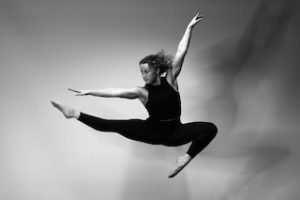 Allison Larsen leaps with leg outstretched.