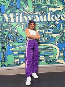 Allison Larsen stands with arms crossed in front of 