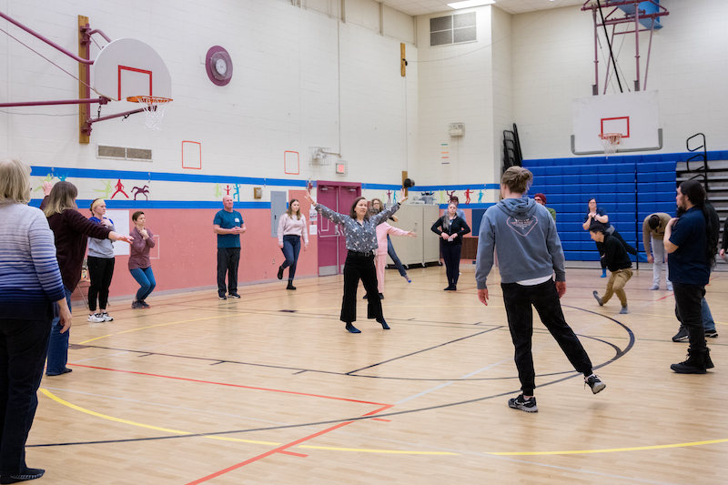 Educators in the gym of Van Hise Elementary School in Madison take part in a dance workshop with Chell Parkins.