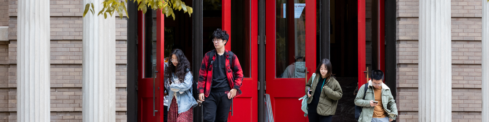 Students walking out of the Education Building's red doors