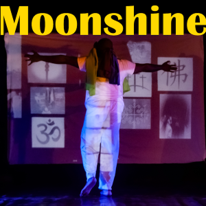 A Black dancer wearing white stands with his back turned, arms outstretched, facing a wall with projections of religious symbols and other iconography.