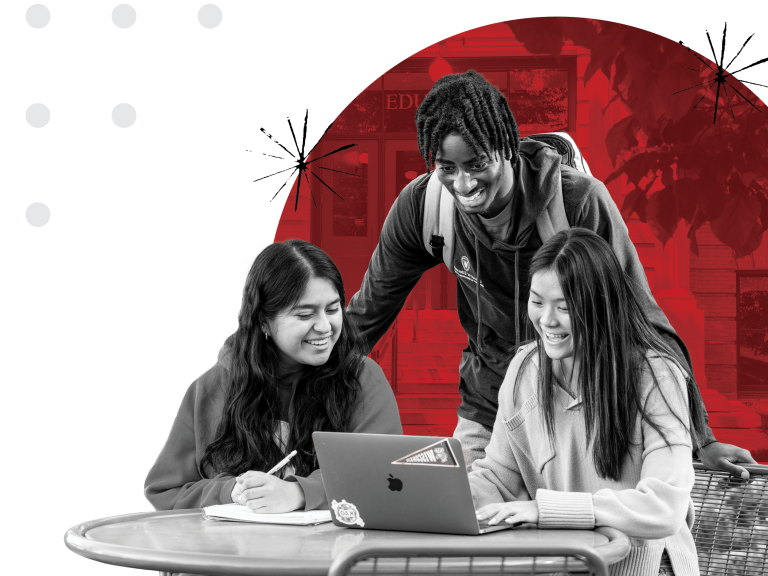 Students gathering around computer, smiling