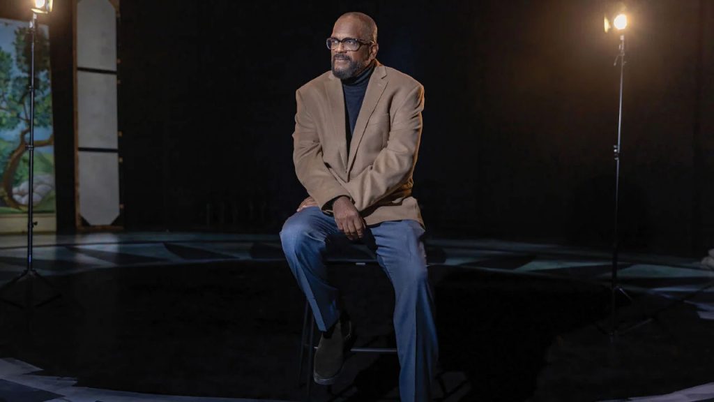 Baron Kelly sitting on a stool in an interview