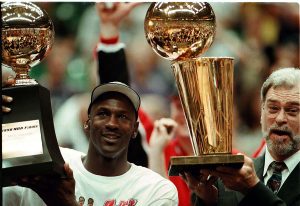 Michael Jordan and Phil Jackson holding NBA championship trophy