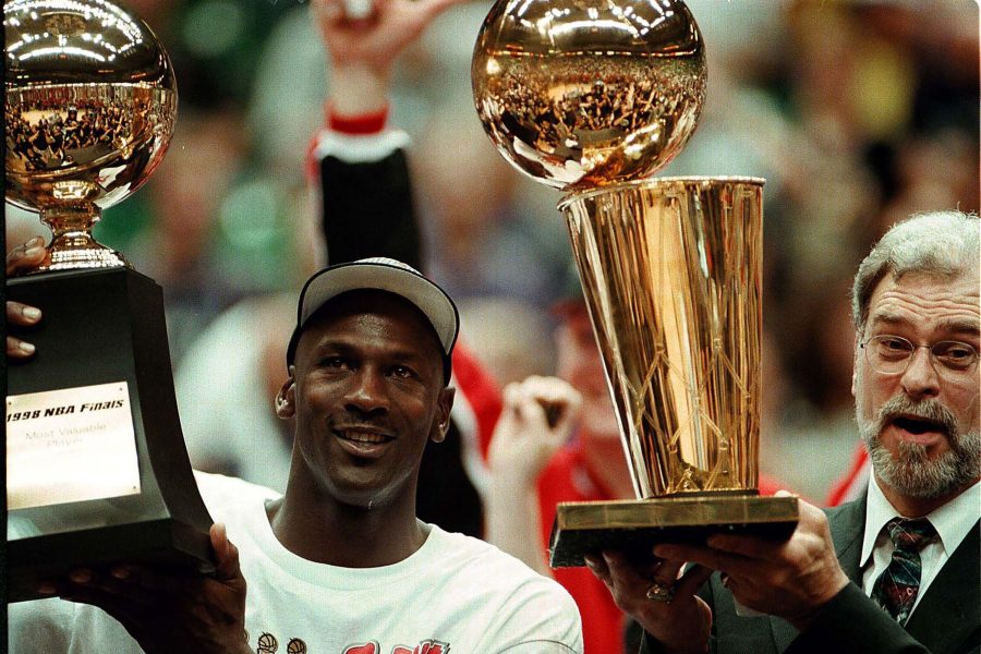 Michael Jordan and Phil Jackson holding NBA championship trophy