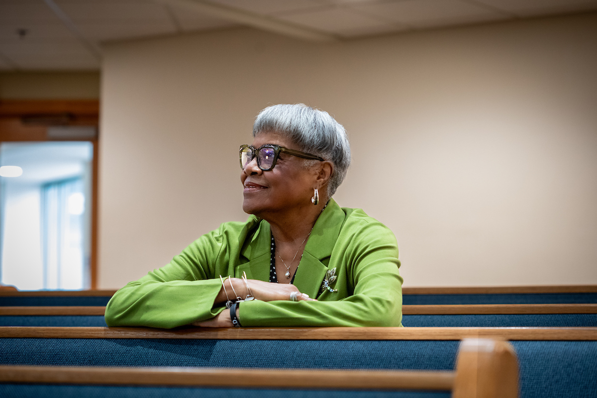 Woman who was part of the study sits in pews