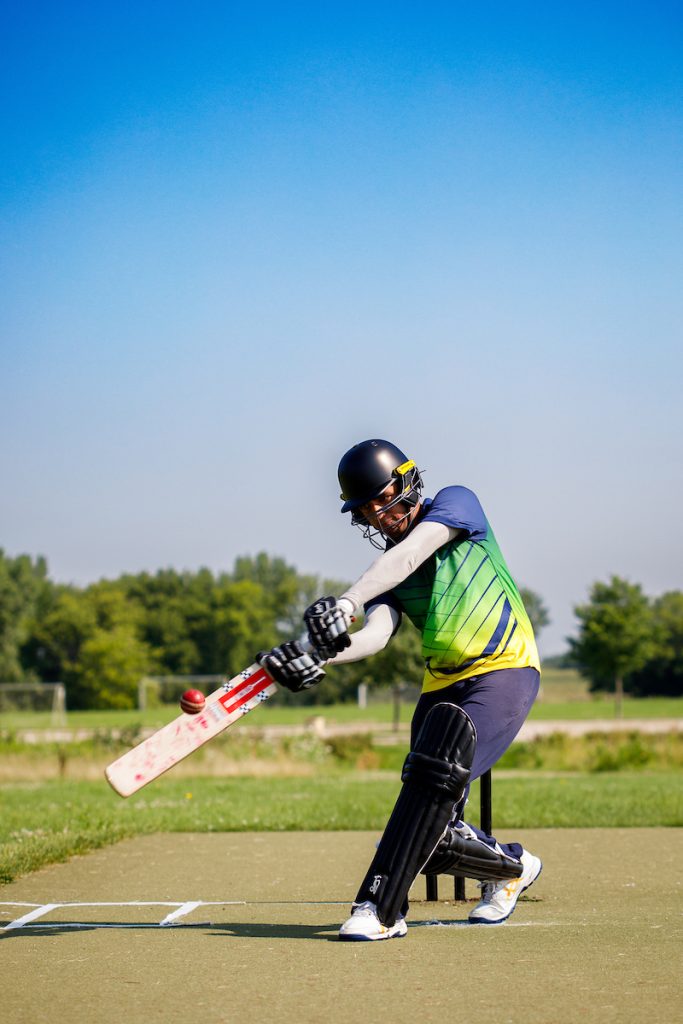 man swings cricket bat