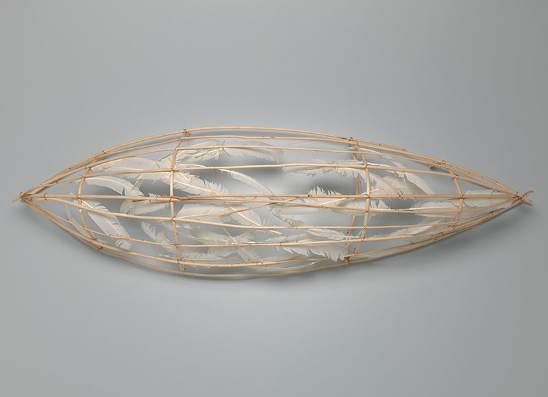 Art piece of a canoe made of feathers and copper wire