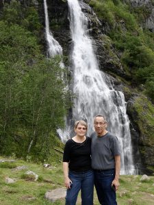 Truman and Nancy Lowe posing in front of a waterfall out in nature