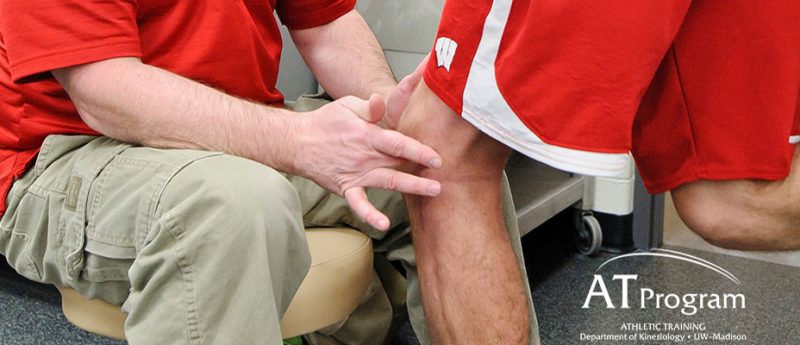 Athletic Trainer examining a knee