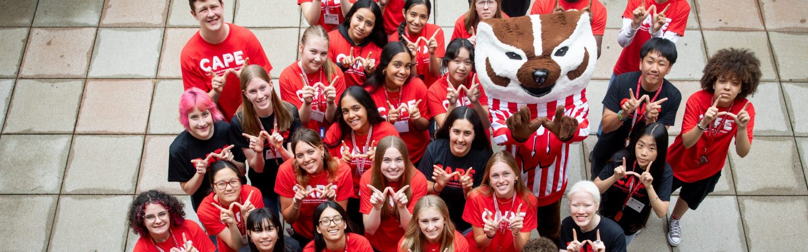 CAPE 2025 students stand on a patio with Bucky.
