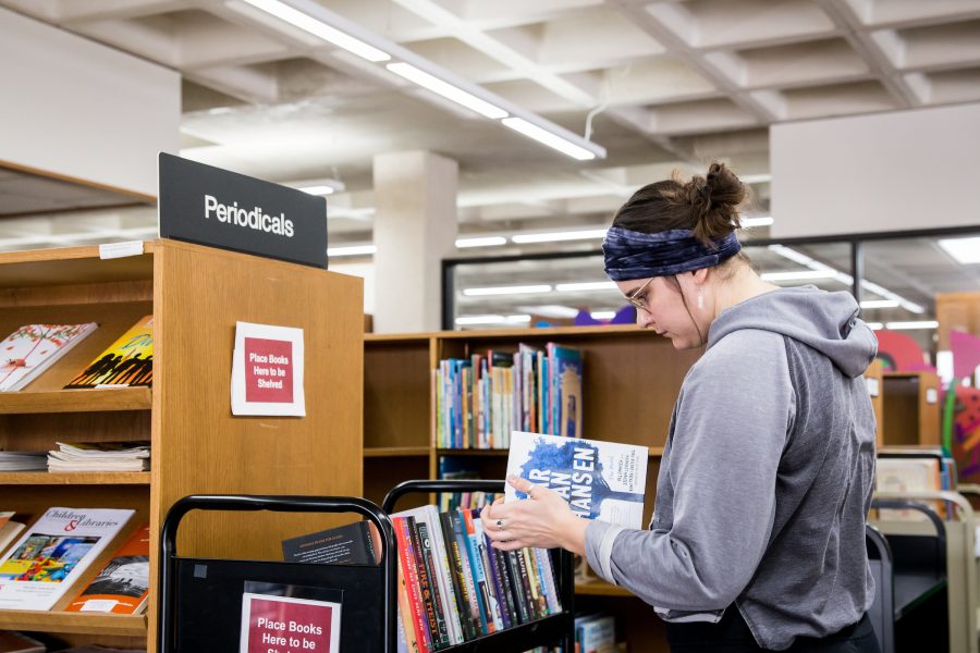 a person shelving books at a library