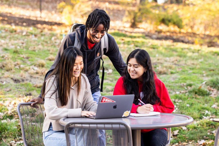 three students studying at a table