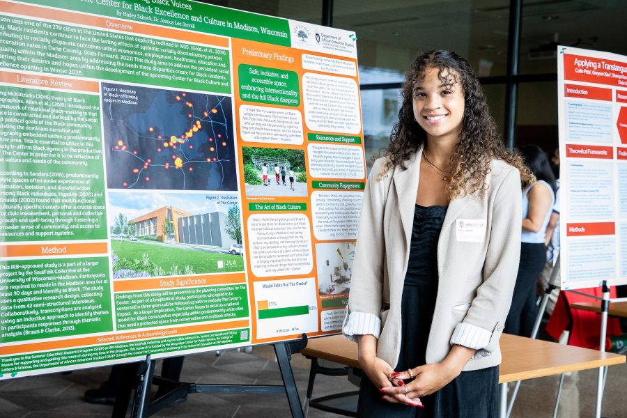 Hailey Schock stands in front of a SERP research poster.