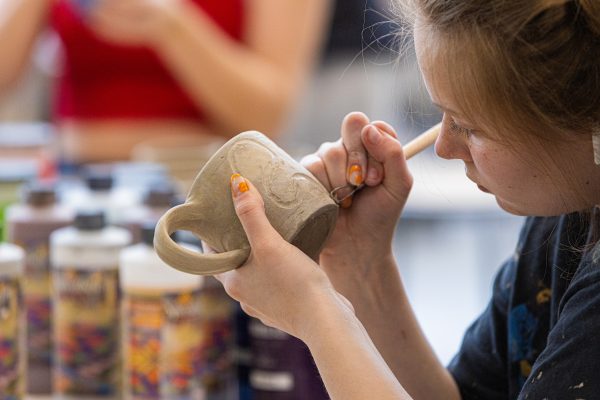 Student working with clay creating a mug