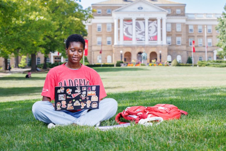 Student with laptop working on bascom hill